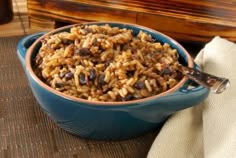 a blue bowl filled with rice and raisins