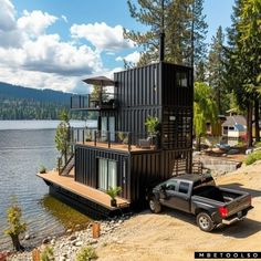 a truck is parked in front of a house made out of shipping containers on the beach