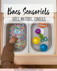 a child's hands playing with colorful beads in their trays