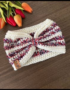 a close up of a headband on a table with tulips in the background