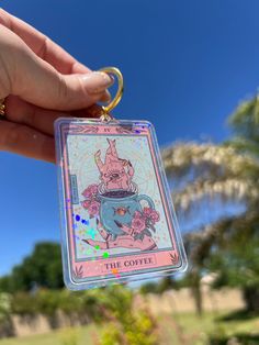 a person holding up a keychain with an image of a princess on it