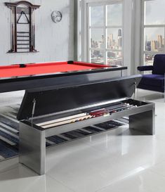 a pool table in the middle of a room with chairs and a clock on the wall