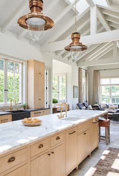 a large kitchen with an island in the middle and lots of windows on both sides