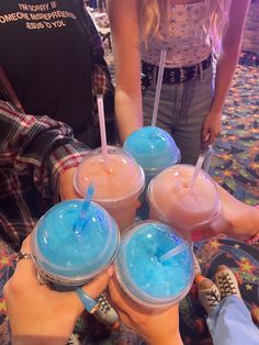 four people are holding cups with drinks in them