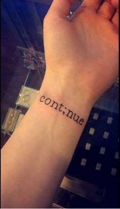 someone has a tattoo on their wrist that says continue