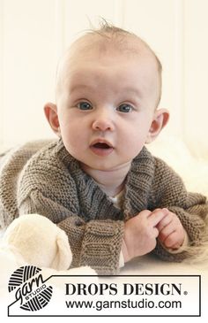 a baby wearing a sweater and holding a teddy bear in it's lap with the words drops design