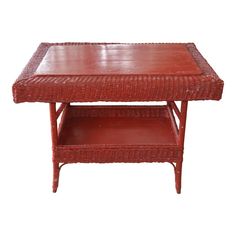 a red wicker coffee table with two shelves on each side and one shelf under the top