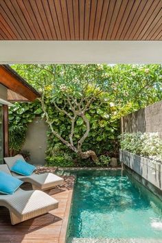 an outdoor swimming pool with lounge chairs next to it