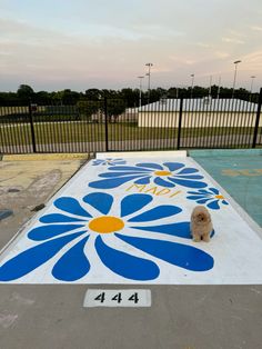 a dog is sitting in the middle of a painted flower design on a skateboard ramp