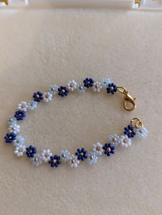 a beaded bracelet with blue and white flowers