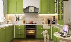 a small kitchen with green cabinets and white counter tops, an oven in the center