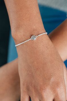 CBM-310 Dainty but enduring, this .925 sterling silver adjustable bracelet affixes a circular charm with your loved one's solidified ashes to a delicate, yet sturdy chain. Dimensions & Details:Setting: 8mmChain: .925 sterling silver 1.8mm rounded box chain | adjustable up to 8" All dimensions are approximate and may vary slightly with every casting. This piece can accommodate up to four characters of engraving, including spaces and simple symbols, along the back of its setting. Examples of the f Dainty Adjustable Jewelry With Polished Finish, Everyday Silver Jewelry With Round Stone, Minimalist Sterling Silver Jewelry For Friendship, Silver Jewelry With Adjustable Chain For Friendship, Sterling Silver Chain Bracelet For Anniversary, Sterling Silver Round Jewelry For Friendship, Sterling Silver Adjustable Chain Bracelet For Friendship, Dainty White Gold Round Charm Bracelet, Silver Birthstone Jewelry For Friendship