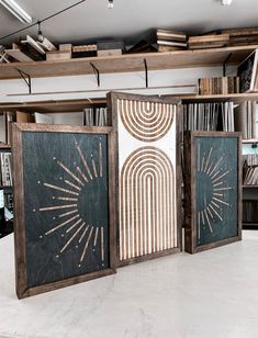 three wooden panels with designs on them in a room filled with books and other items