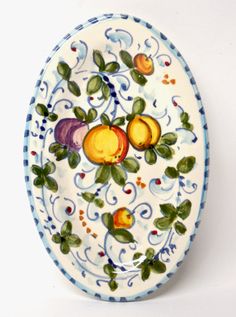 a decorative plate with fruit painted on the front and sides, sitting on a white surface