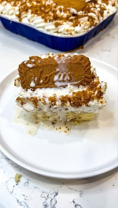 a piece of cake sitting on top of a white plate next to a blue casserole dish