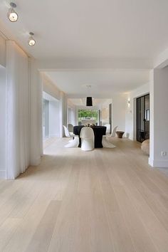 an empty living room with white walls and wood flooring on the other side of the room