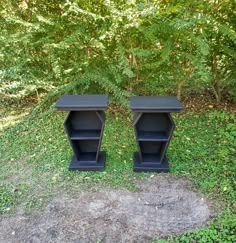 two black shelves sitting on top of a grass covered field