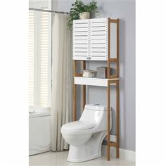 a white toilet sitting next to a tall wooden shelf filled with lots of storage space