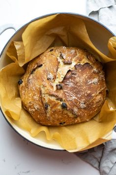 a loaf of bread sitting in a pan on top of a table next to napkins