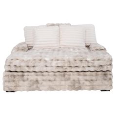 a white couch with two pillows on it's back and one pillow in the middle