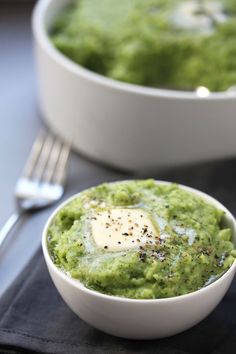 two bowls filled with guacamole and topped with an egg