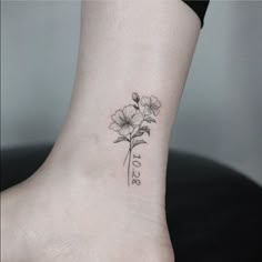 a small flower tattoo on the ankle