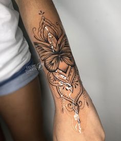 a woman's arm with a tattoo on it and a butterfly in the middle