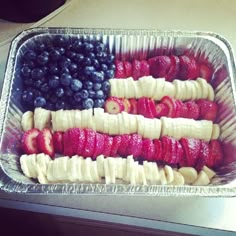 an american flag made out of bananas, strawberries and blueberries in a tray