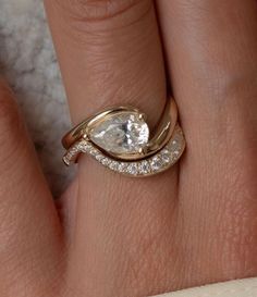 a woman's hand with a gold ring and two diamond rings on her finger