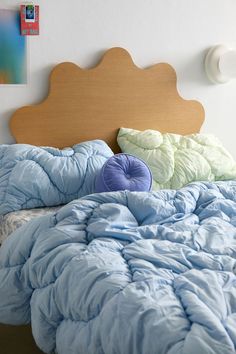 an unmade bed with blue comforter and pillows