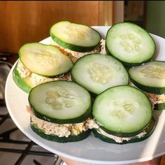 cucumber sandwiches are arranged on a white plate