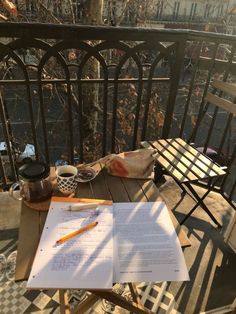 an open notebook sitting on top of a wooden table next to a cup of coffee