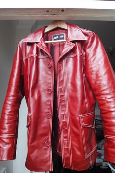 a red leather jacket is on display in a closet