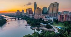 an aerial view of the city and river at sunset