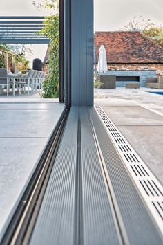 an empty bench sitting in the middle of a patio next to a building with lots of windows