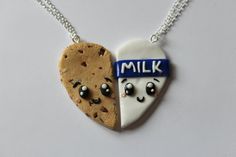 two cookies in the shape of hearts with faces painted on them are hanging from a silver chain