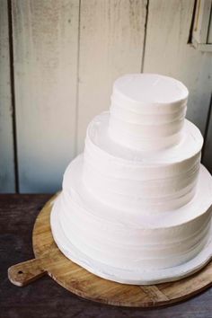 a white cake sitting on top of a wooden board