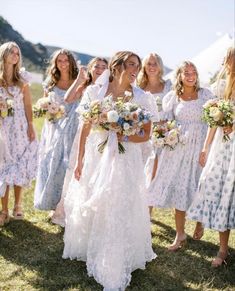 a group of women standing next to each other on top of a grass covered field