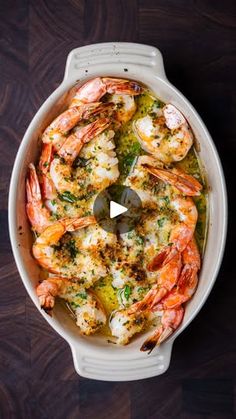 a casserole dish filled with shrimp and broccoli, garnished with parsley