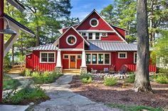 a red house surrounded by trees in the woods