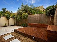 a wooden deck in the middle of a yard