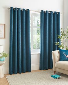 a living room with blue curtains and a white rug