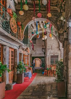 an alley way with lots of potted plants and hanging decorations