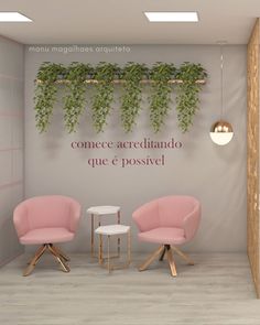 two pink chairs sitting next to each other in front of a wall with plants on it