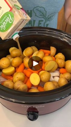 someone is pouring potatoes and carrots into the slow cooker to cook them in