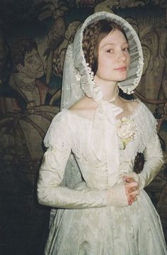 a woman dressed in an old fashion wedding gown