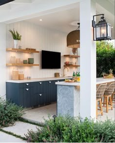 an outdoor kitchen with blue cabinets and white walls