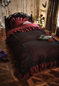 a bed with red and black bedspread on top of it