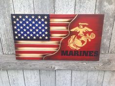 an american flag with the words marines painted on it and a marine emblem in red, white, and blue