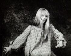 a black and white photo of a woman with her hands out in front of her face